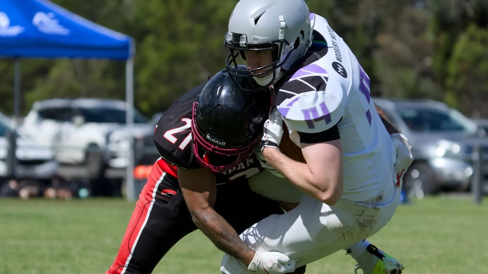 Spartans number 21 tackles a ball carrier in white around the waist